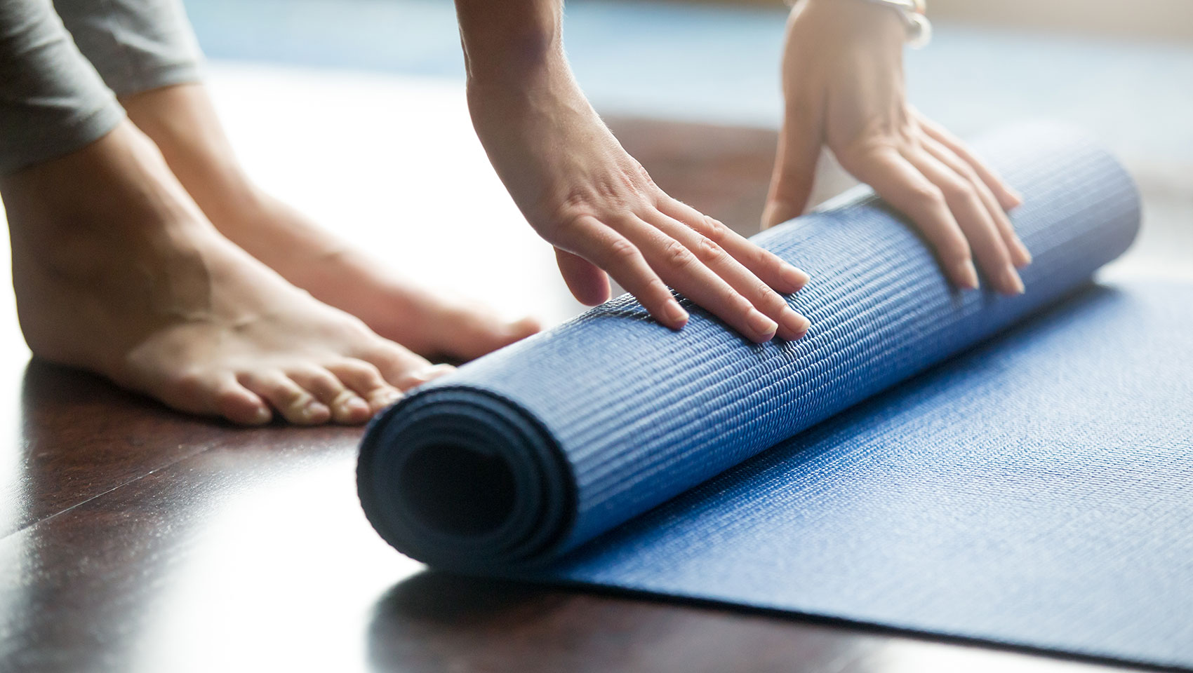Woman rolling yoga mat